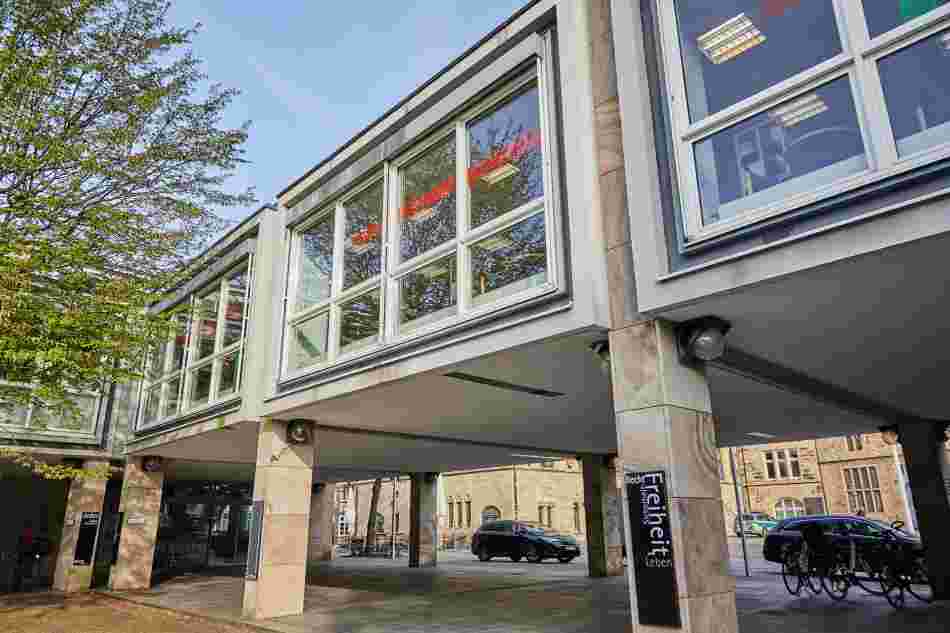 Rote und grüne Folien und Bleche ziehen sich innen wie außen an den großen Fenstern des Gebäudes der Osnabrücker Stadtbibliothek entlang.