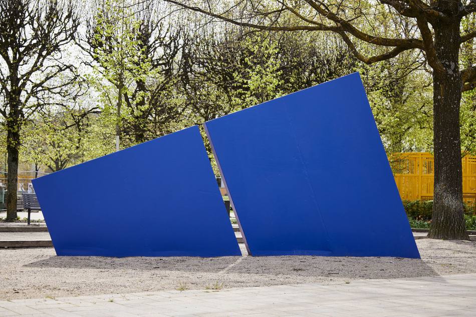 Ein blaues Dreieck, das wie ein Zacken aus der Erde ragt und in der Mitte geteilt ist.