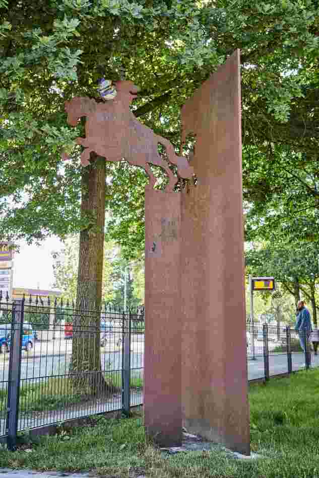 Neben einem Zaun steht Skulptur 